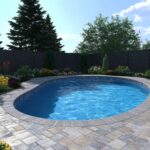 Stahlwandpool Oval im Garten mit Steinumrandung und bunter Bepflanzung bei Sonnenschein